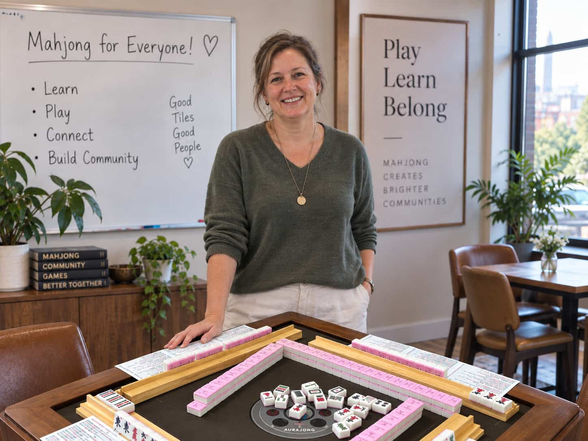 American Mahjong teacher standing beside an AURAJONG automatic mahjong table in a bright community learning space