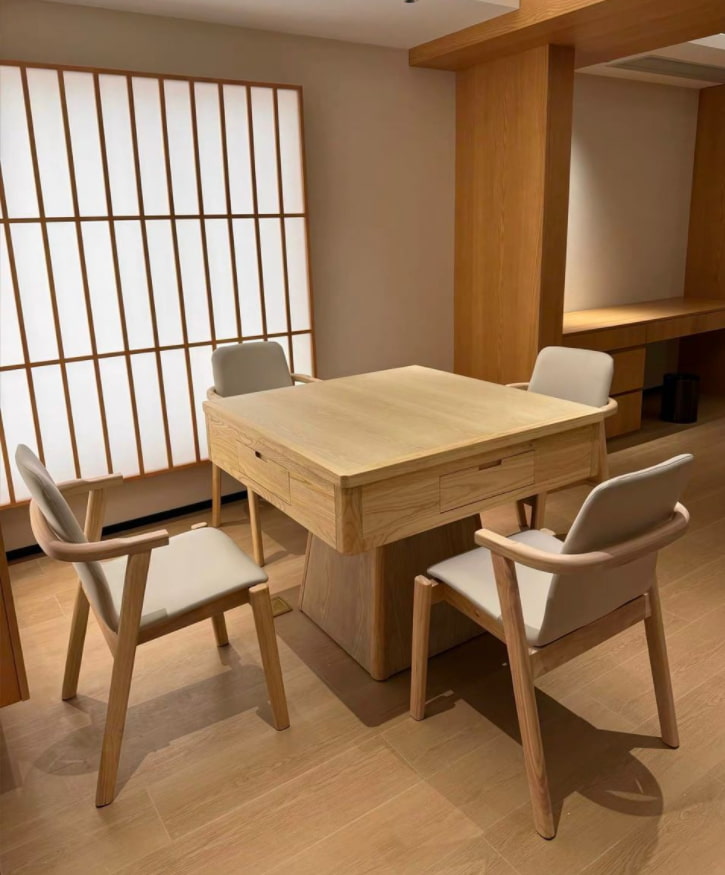 AURAJONG R1 automatic American Mahjong table in a warm home interior with light oak finish and four upholstered chairs