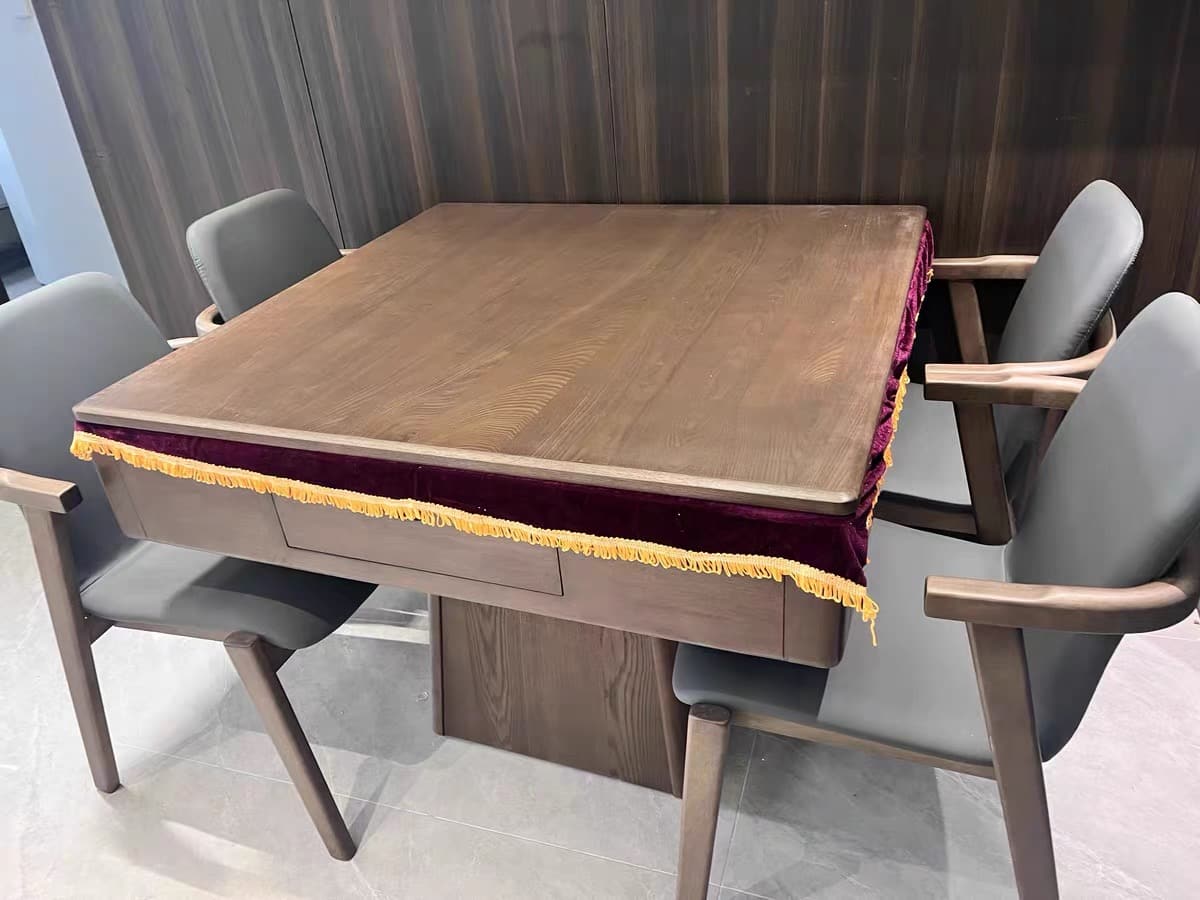 AURAJONG R1 automatic American Mahjong table with dining cover in a real home setting, featuring a walnut finish and four upholstered chairs