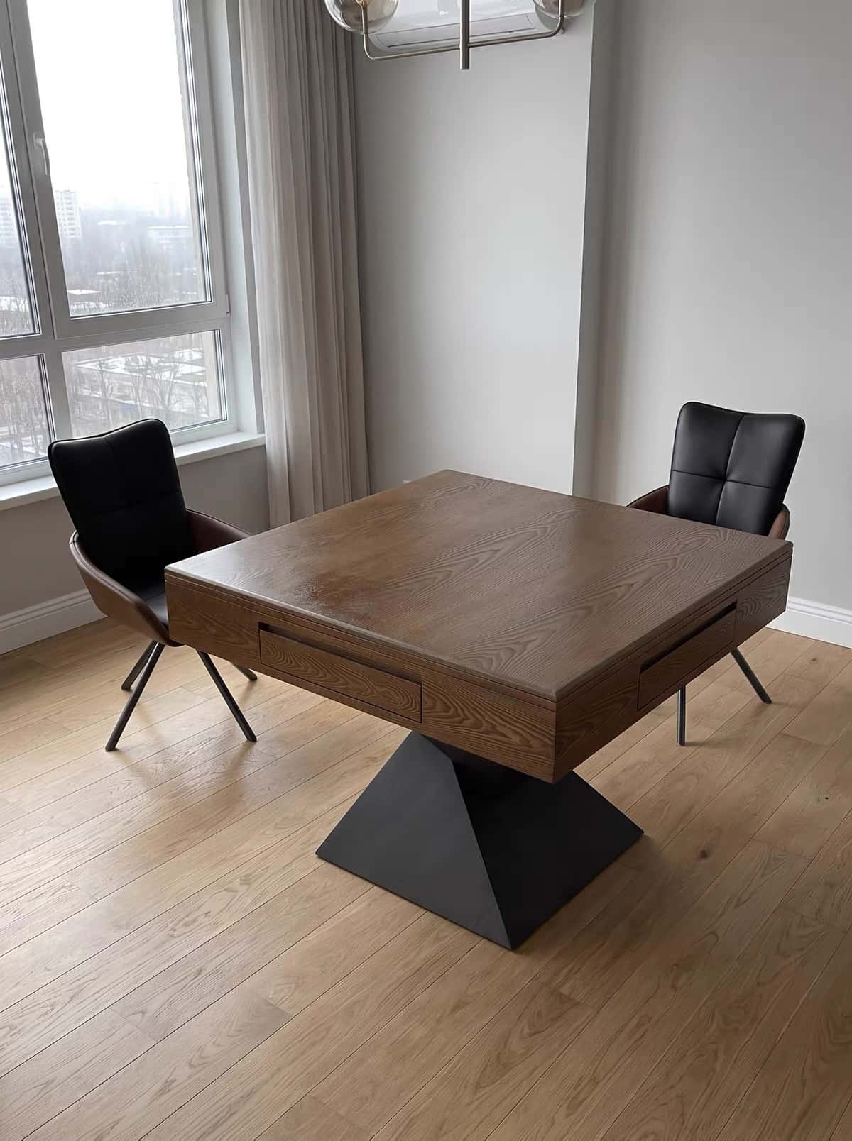 AURAJONG R3 automatic American Mahjong table in a modern home with a walnut finish, black pedestal base, and two black chairs