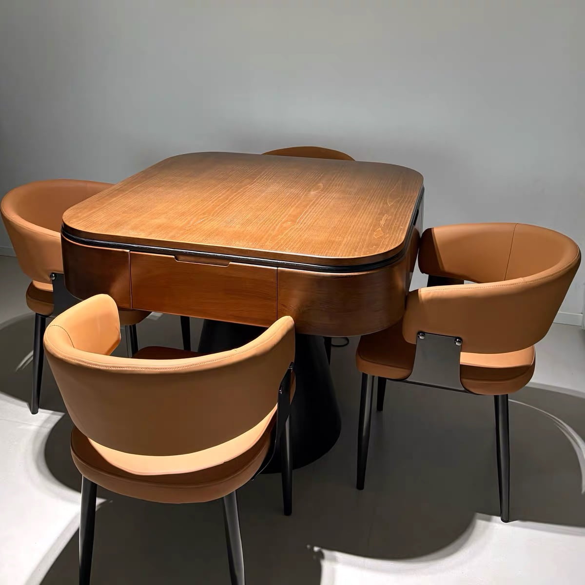 AURAJONG R5 automatic American Mahjong table with walnut finish and black pedestal base, surrounded by four brown upholstered chairs