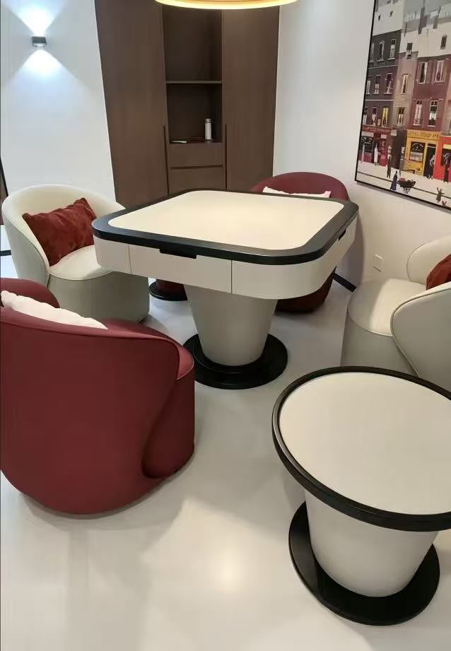 AURAJONG S1 automatic American Mahjong table with ivory finish, black trim, matching side tables, and mixed red and ivory lounge chairs