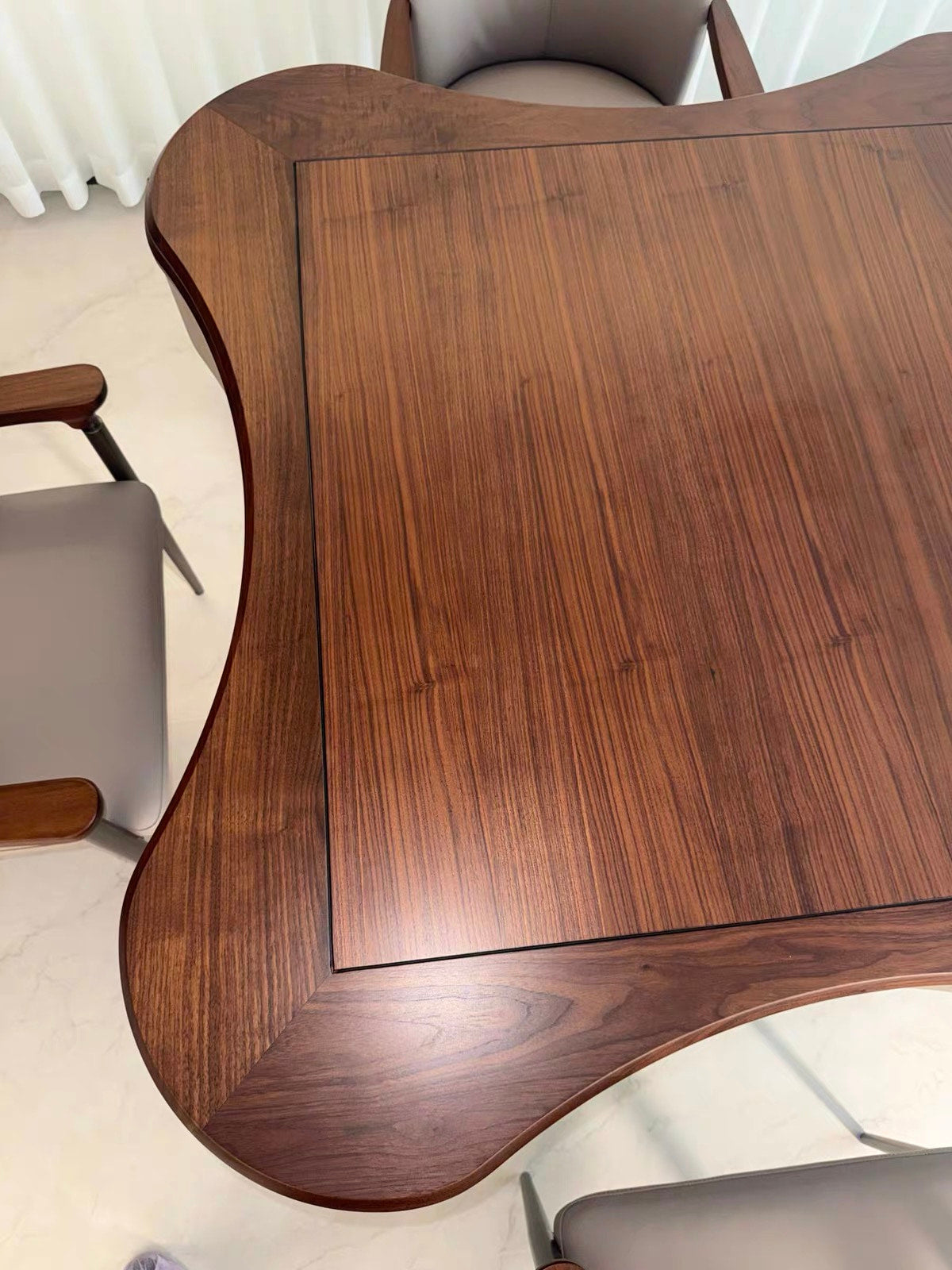 Close view of AURAJONG S2 automatic American Mahjong table showing the walnut dining cover and sculptural tabletop shape