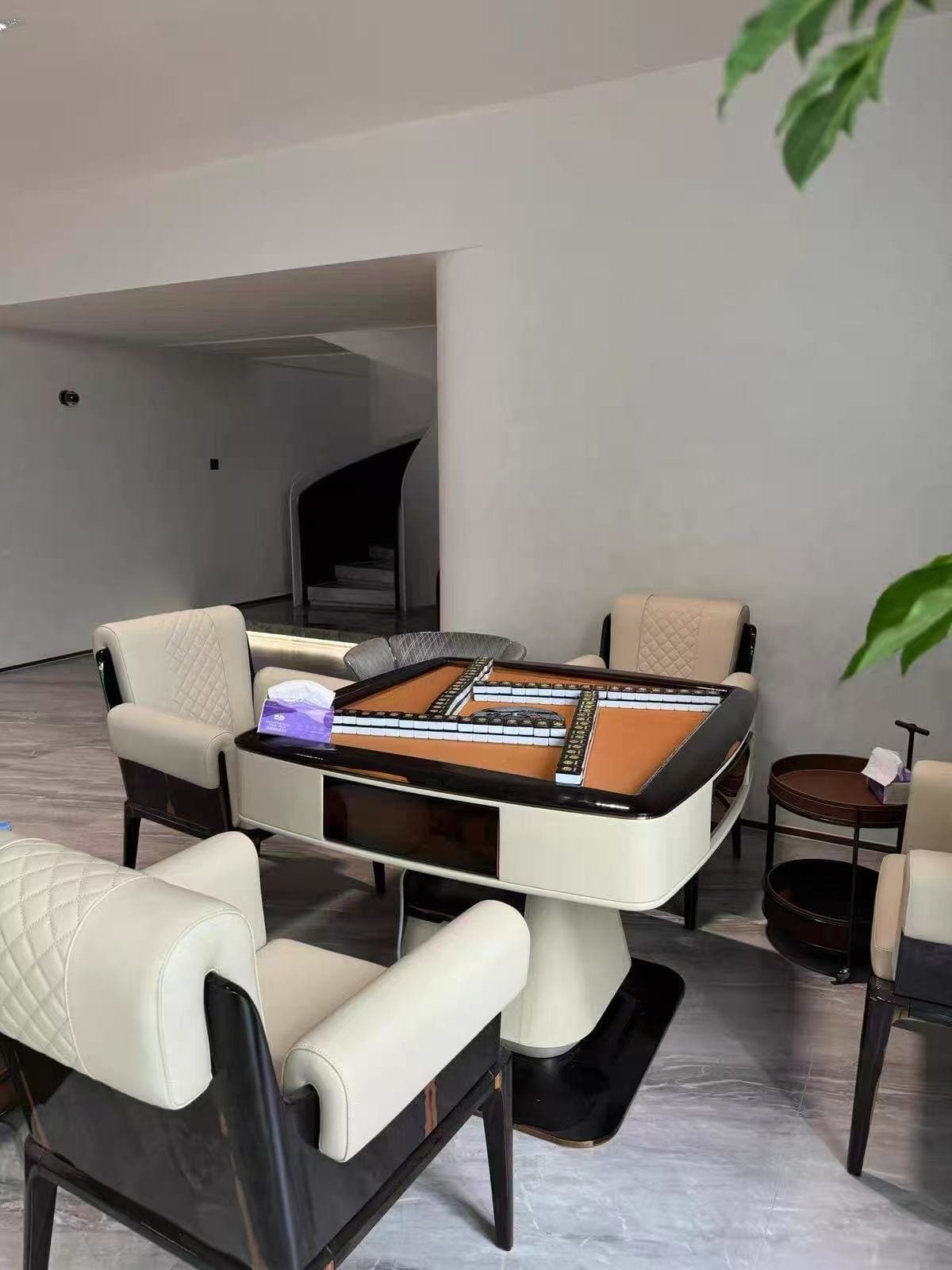 AURAJONG S3 automatic American Mahjong table set up for play with cream upholstered chairs in a modern home interior