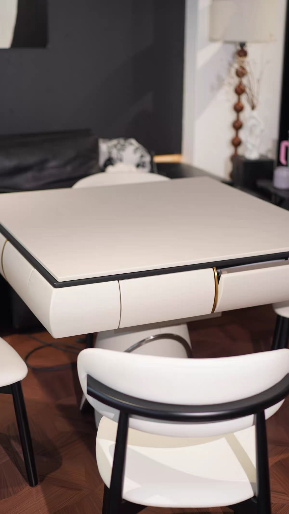 AURAJONG S4 automatic American Mahjong table with closed top shown from a side angle in a luxury modern interior with ivory chairs